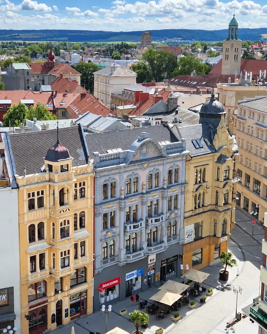 Historické domy v centru Opavy z výšky, v pozadí věž a zelené kopce